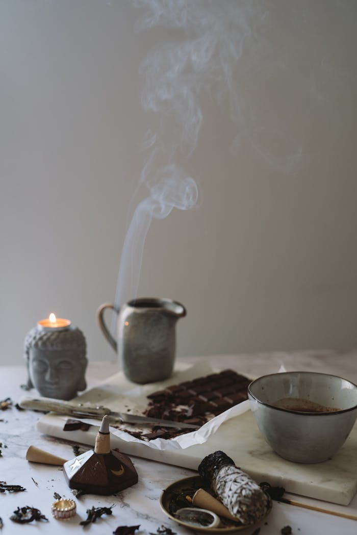 A serene arrangement featuring chocolate, incense, and a Buddha candle, creating a calm atmosphere.